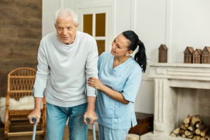 friendly caregiver helping an elderly man